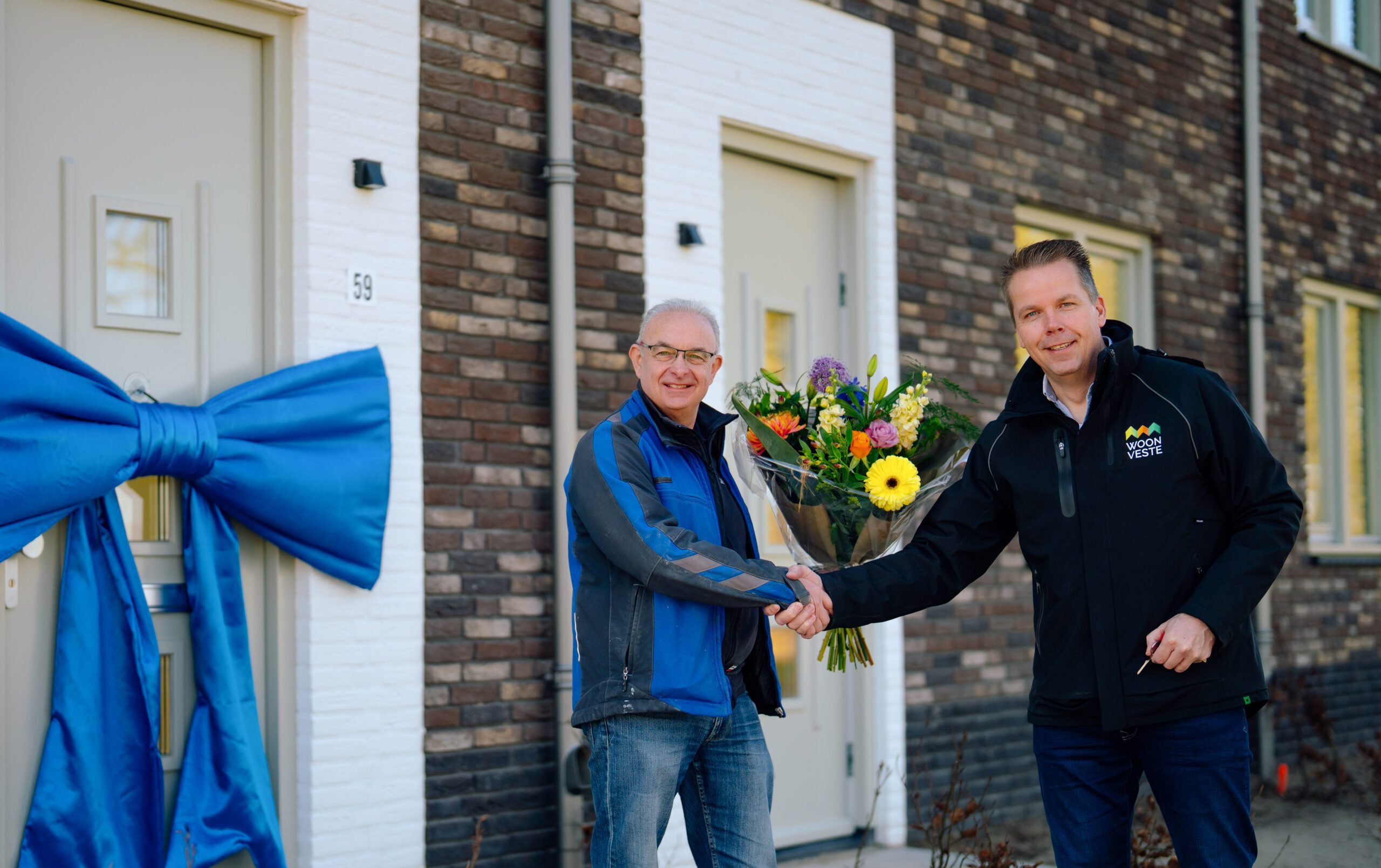 Uitvoerder-Tony-van-Riel-van-Janssen-de-Jong-Bouw-overhandigt-de-sleutel-van-de-laatste-huurwoningen-van-Geerpark-aan-Marcel-van-den-Oever-van-woningcorporatie-Woo-1-scaled-e1741268352274